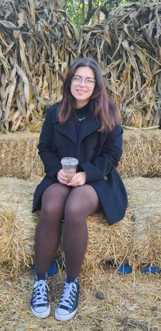 Mykayla Romo-Ramirez poses on a bail of hay. 