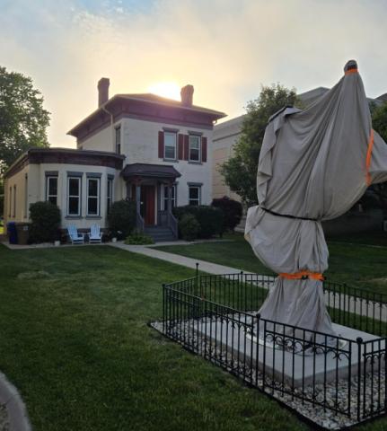 The sculpture is wrapped as it sits in front of the house. 