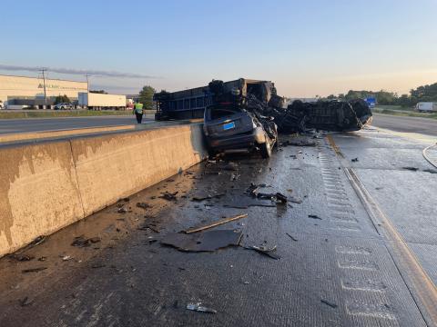 A photo of the first crash shows a burnt-out semi straddling the median wall. 