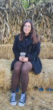 Mykayla Romo-Ramirez poses on a bail of hay. 