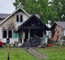 Heavily damaged home, with scorched siding next door. 