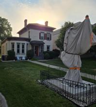 The sculpture is wrapped as it sits in front of the house. 