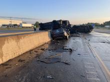 A photo of the first crash shows a burnt-out semi straddling the median wall. 