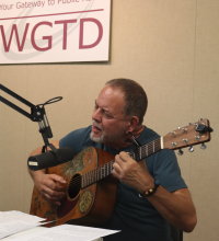 Brent Mitchell playing guitar and signing in the WGTD studio